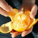 Hands peeling an orange mindfulness exercise for the Moon-Mind way of living
